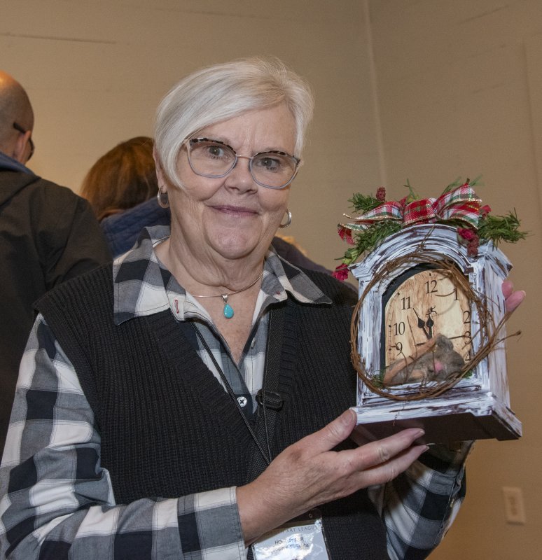 Ellendale artist Rita Deakyne of Felties by Rita holds a sweet sleeping mouse who found a bed in a clock.